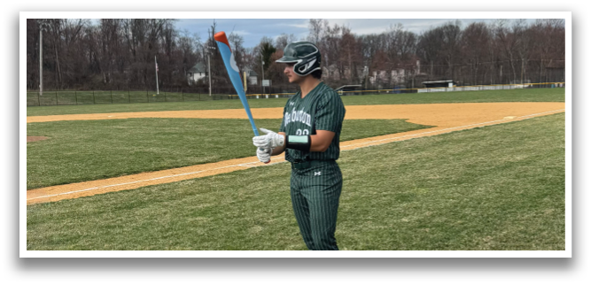 A baseball player holding a bat on a field. Description generated by AI