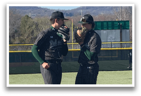 Two men standing on a baseball field. Description generated by AI