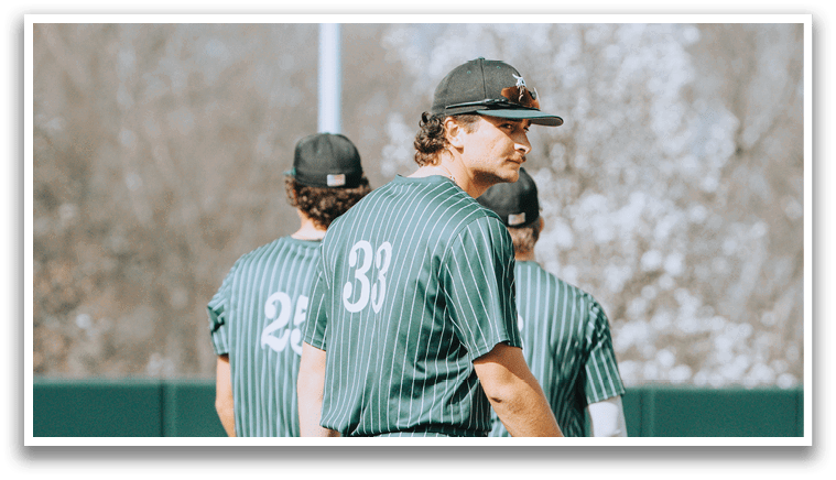 A baseball player wearing a green and white striped uniform. Description generated by AI