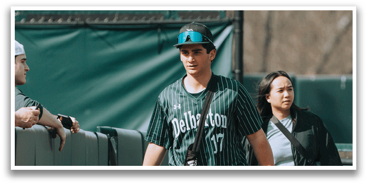 A baseball player wearing a green and white uniform. Description generated by AI