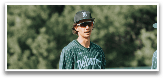 A baseball player wearing a green and white uniform. Description generated by AI