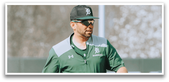 A man wearing a green jacket and a black hat. Description generated by AI