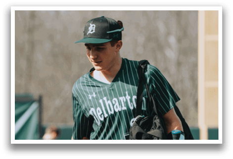 A man wearing a green and white striped baseball uniform. Description generated by AI