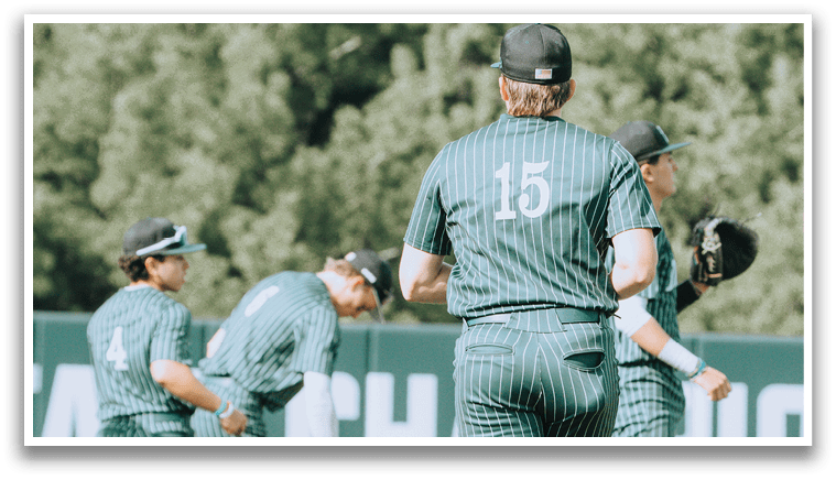 A group of baseball players wearing green and white uniforms. Description generated by AI