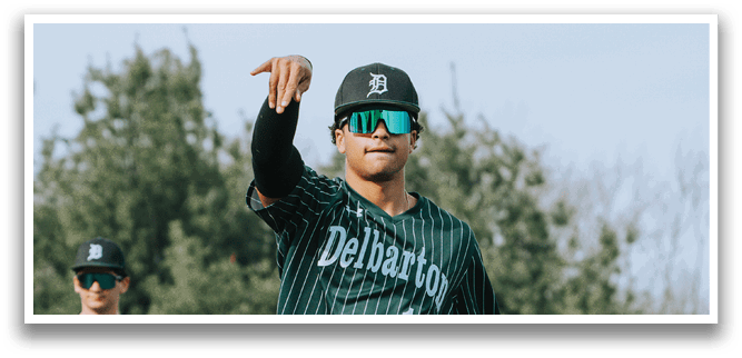 A baseball player wearing a green and white uniform. Description generated by AI