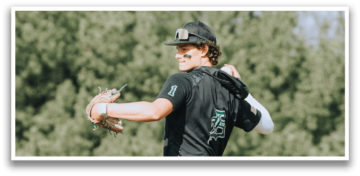A baseball player wearing a black shirt and green and white pants is holding a baseball glove. Description generated by AI