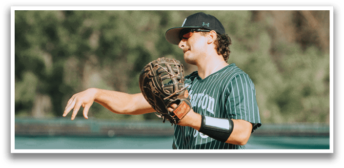 A baseball player wearing a green and white uniform. Description generated by AI