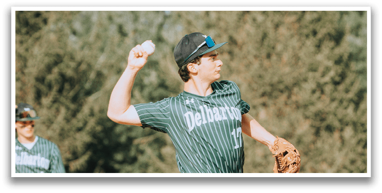 A baseball player in a green and white uniform is pitching a ball. Description generated by AI