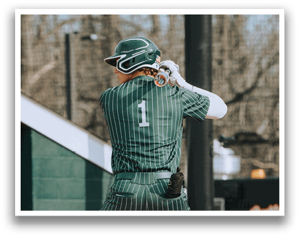 A baseball player in a green and white uniform is swinging a bat. Description generated by AI