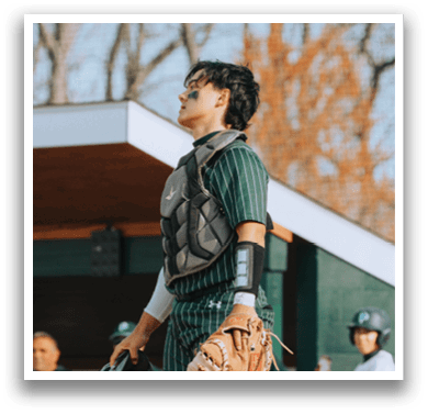 A baseball player wearing a green and white uniform. Description generated by AI