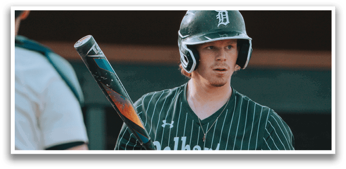 A baseball player wearing a green and black uniform. Description generated by AI