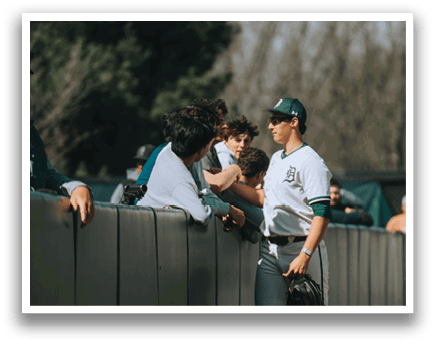 A group of people standing in front of a fence. Description generated by AI