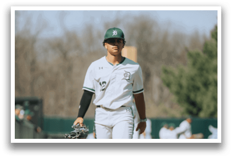 A baseball player wearing a white uniform with a green hat and green stripes on his pants. Description generated by AI