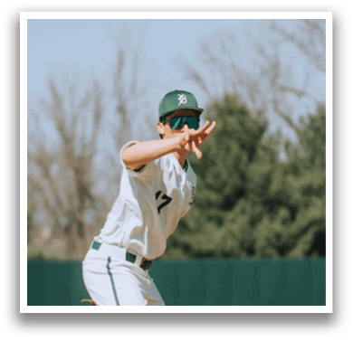A baseball player wearing a white uniform and green socks is running towards a base. Description generated by AI