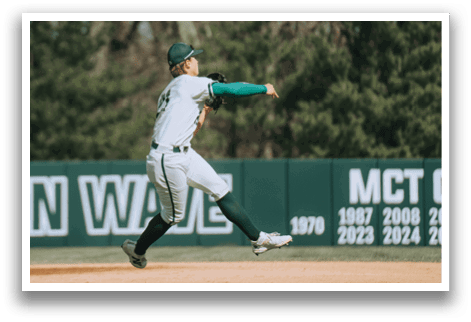 A baseball player in a white and green uniform is throwing a ball. Description generated by AI
