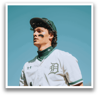 A baseball player wearing a white and green uniform. Description generated by AI