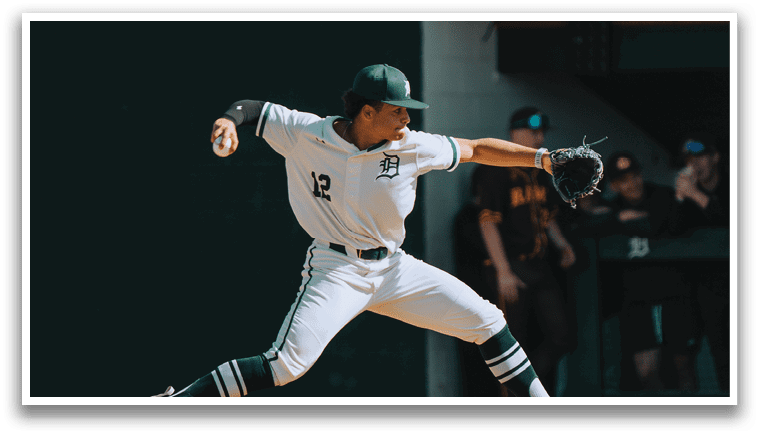 A baseball player in a white uniform is pitching a ball. Description generated by AI
