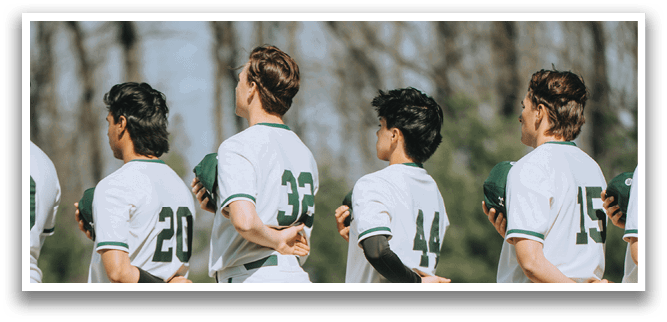 Four baseball players standing on a field. Description generated by AI