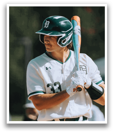 A baseball player in a white uniform holding a bat. Description generated by AI