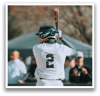 A baseball player is holding a bat, ready to swing. Description generated by AI