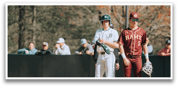 A baseball player in a green and white uniform stands on the field. Description generated by AI