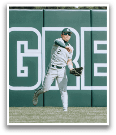 A baseball player wearing a white uniform and a green hat. Description generated by AI