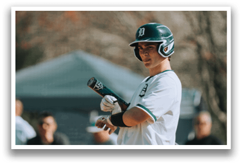 A baseball player holding a bat. Description generated by AI