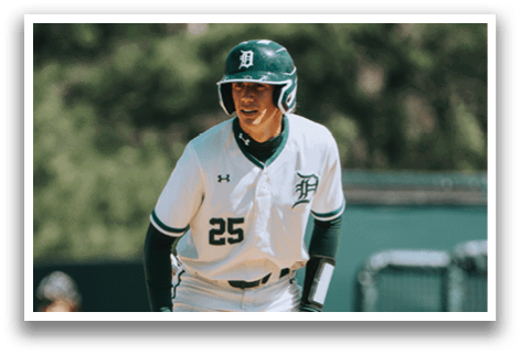 A baseball player wearing a green and white uniform. Description generated by AI
