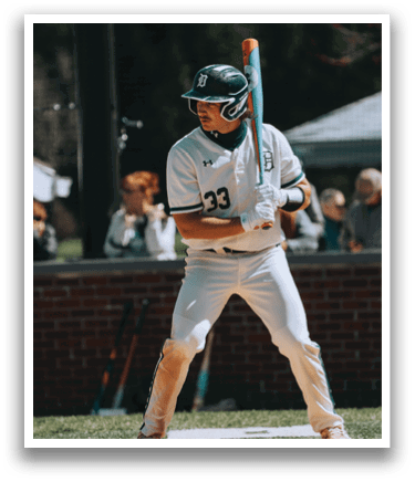 A baseball player in a white uniform holding a bat. Description generated by AI