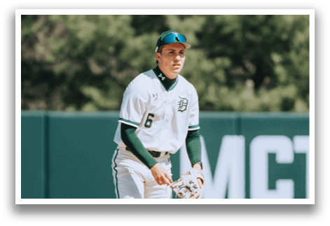 A baseball player wearing a green hat and white uniform. Description generated by AI
