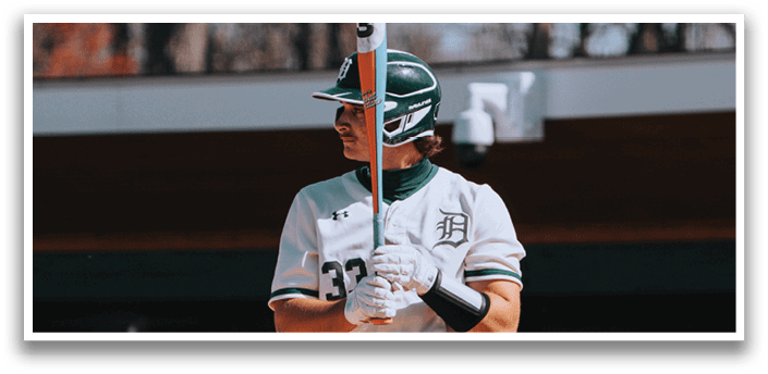 A baseball player holding a bat. Description generated by AI