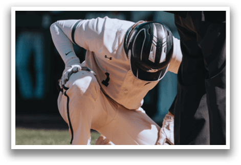 A baseball player bends over on the ground. Description generated by AI