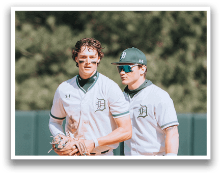 Two baseball players standing on a field. Description generated by AI
