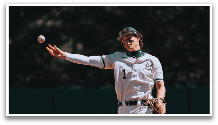 A baseball player wearing a white uniform and a green hat. Description generated by AI