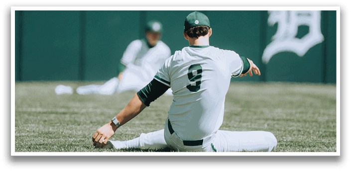 A baseball player is sitting on the ground with his legs crossed. Description generated by AI