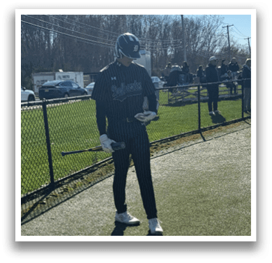 A man holding a baseball bat on a field. Description generated by AI