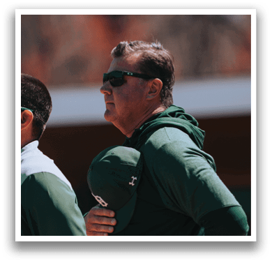 A man wearing a green hat and a green jacket. Description generated by AI