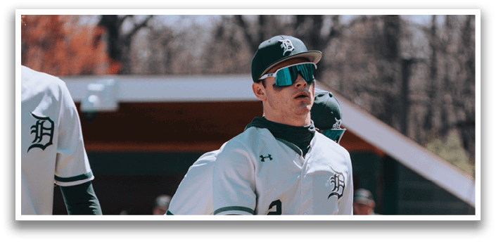 A baseball player wearing a white and green uniform. Description generated by AI