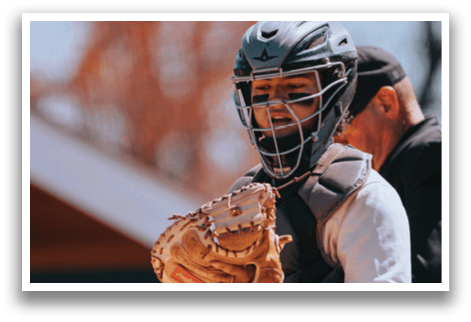A baseball player wearing a helmet and holding a catcher's mitt. Description generated by AI