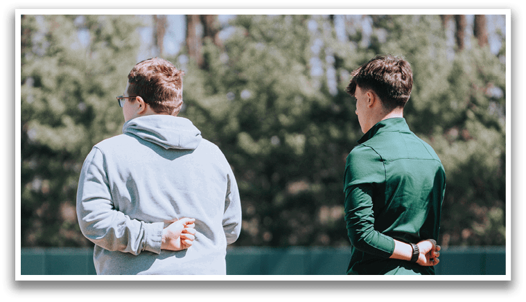 Two men standing on a baseball field. Description generated by AI