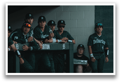 A group of baseball players sitting on a bench. Description generated by AI