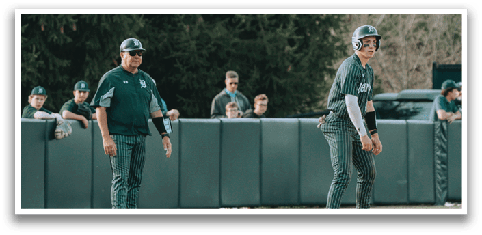 A baseball player in a green and white uniform is standing on the field. Description generated by AI