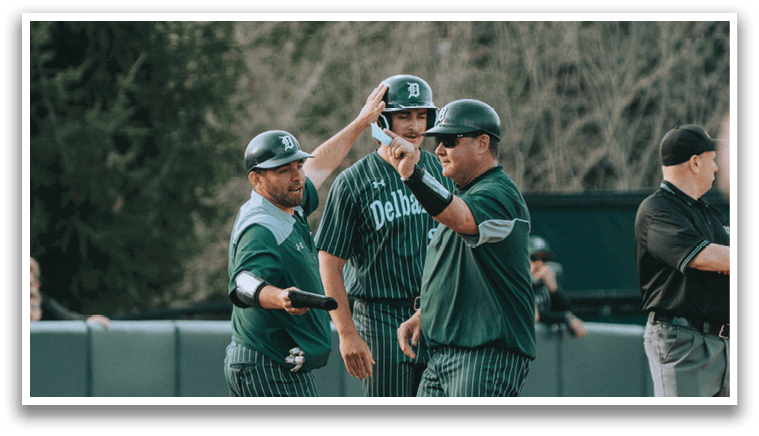 A group of men wearing green and white uniforms are walking on a baseball field. Description generated by AI