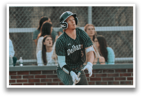 A baseball player in a green and white uniform is holding a bat and preparing to swing. Description generated by AI