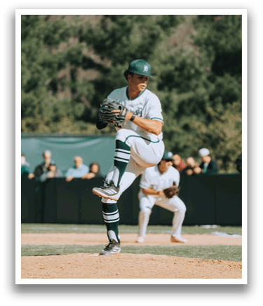 A baseball player in a green and white uniform is pitching a ball. Description generated by AI