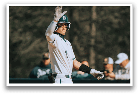 A baseball player wearing a white uniform and a green stripe on his pants. Description generated by AI
