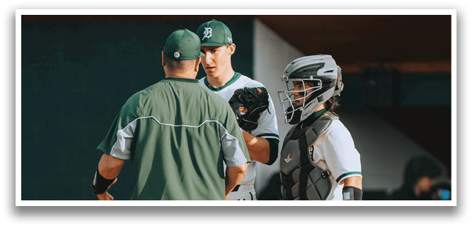 A group of men standing on a baseball field. Description generated by AI
