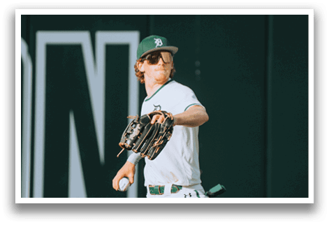 A baseball player wearing a green and white uniform. Description generated by AI