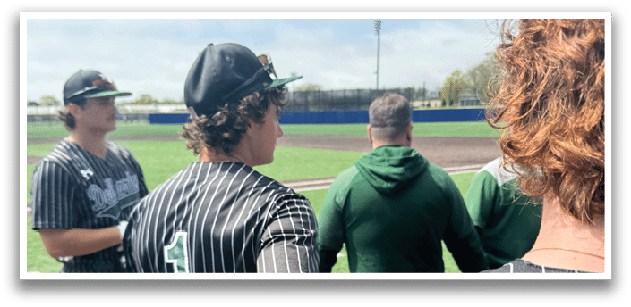 A baseball player wearing a black shirt and green and white pants is holding a baseball glove. Description generated by AI