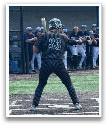 A baseball player is at bat, wearing a black shirt and holding a bat. Description generated by AI